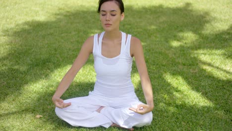 Pretty-serene-young-woman-meditating-outdoors