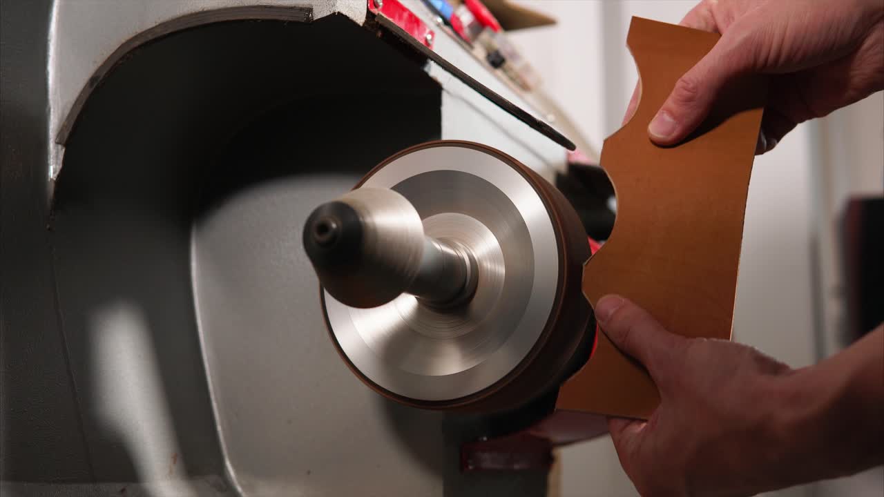 Shoe Repair Technician Using Machine to Polish Leather