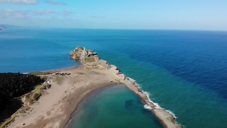 Descripción-Aérea-Del-Faro-De-Castlepoint-Ubicado-En-El-Arrecife,-Paisaje-De-Nueva-Zelanda