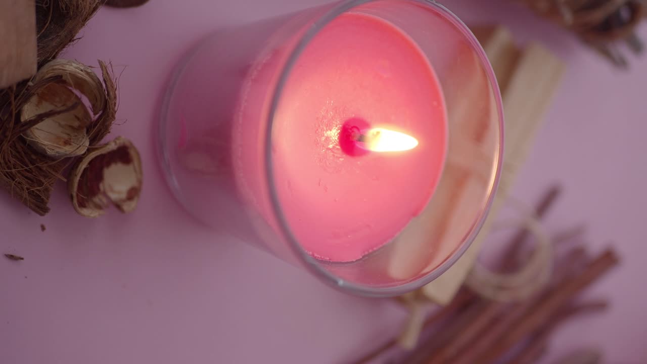 Nærbilde av et rosa lys i et glass