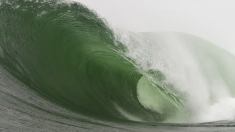 heavy wave folds onto a shallow reef during a storm