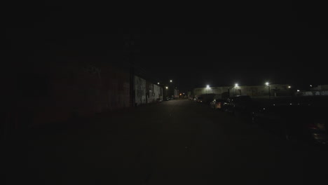 FPV-shot-of-red-and-blue-police-lights-reflecting-on-the-buildings-at-night