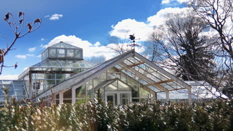 old greenhouse with blue skies and white puffy clouds