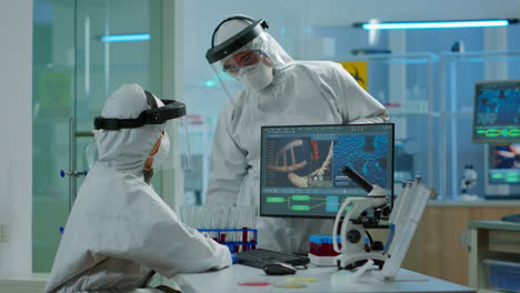 equipo de científicos en traje de proxección discutiendo frente a la pc mirando el desarrollo del virus