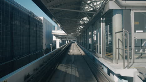 Punto-De-Vista-Del-Monorraíl-Yurikamome-Que-Llega-A-La-Estación-De-Tren-En-Tokio,-Japón-Durante-La-Pandemia