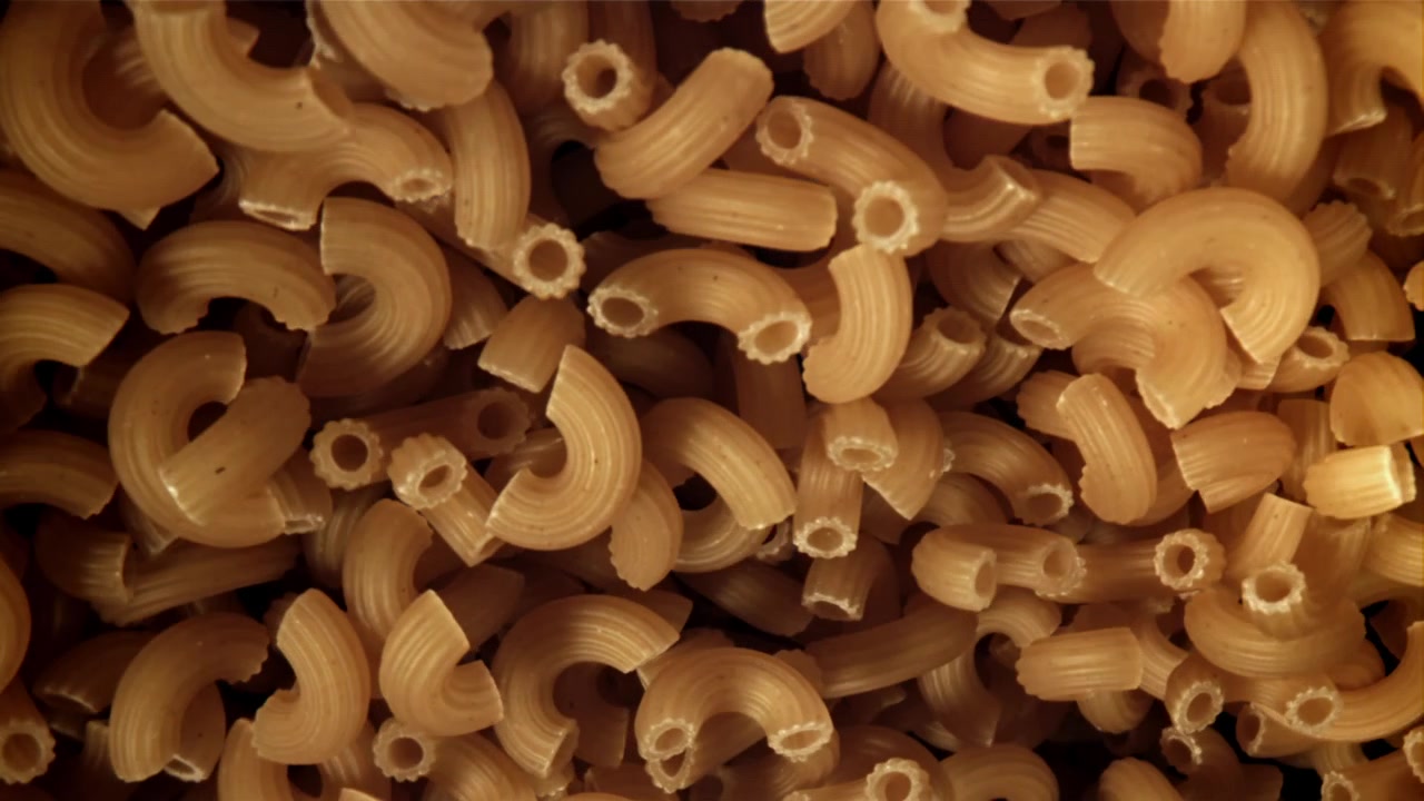 Primo piano di maccheroni secchi con luce mutevole.