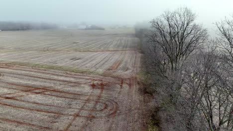 farm-filed-aerial-over-trees-in-winter-in-yadkin-county-nc,-north-carolina