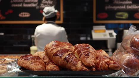 freshly baked croissants in a bakery display case