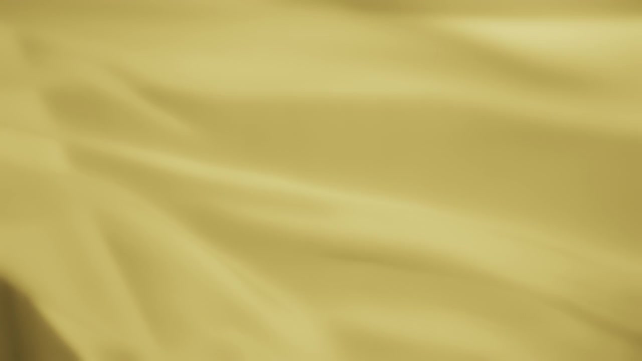 Texture background of yellow chiffon fabric flowing in the wind. Slow motion