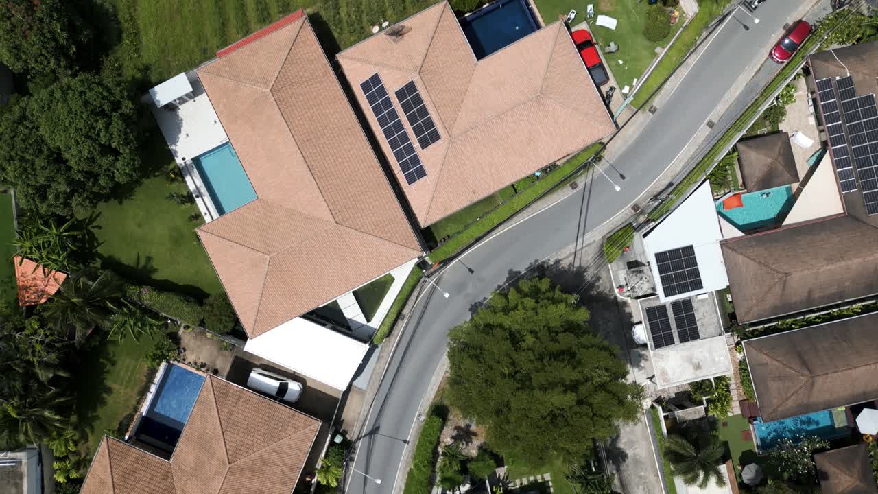 Top-down drone shot of homes and village streets in a small Phuket town, surrounded by tropical greenery. Thailand scenery of beautiful rooftops and homes. villages around nature. vacation travel.