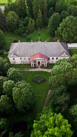 kirna manor is seen from above in a vertical drone video highlighting its elegant design picturesque gardens and surrounding nature in the estonian countryside