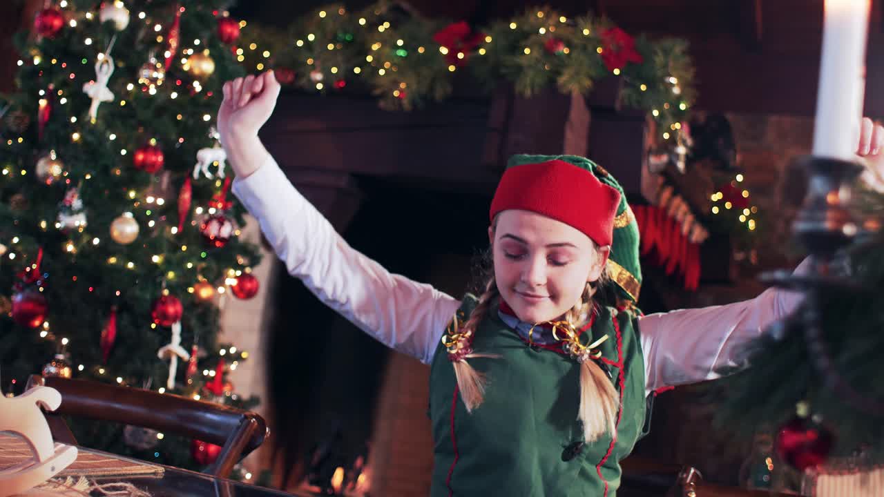 An elf girl wakes up and stretches in a room near a Christmas tree and decorations