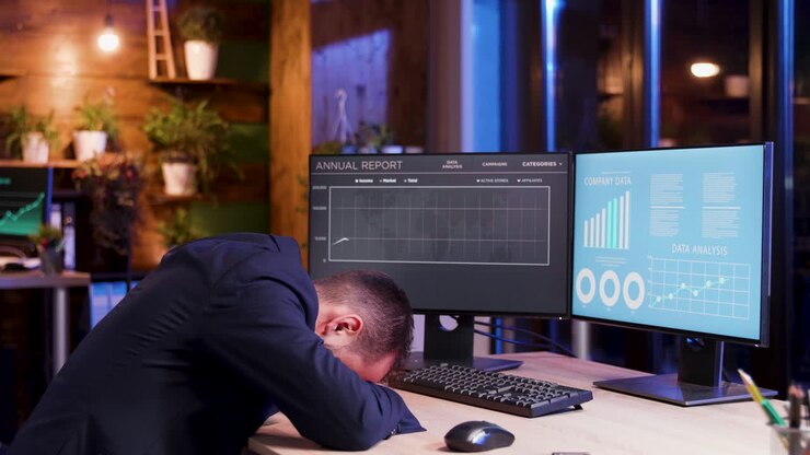 Erschöpfter Geschäftsmann schläft an seinem Schreibtisch in einem modernen Büro