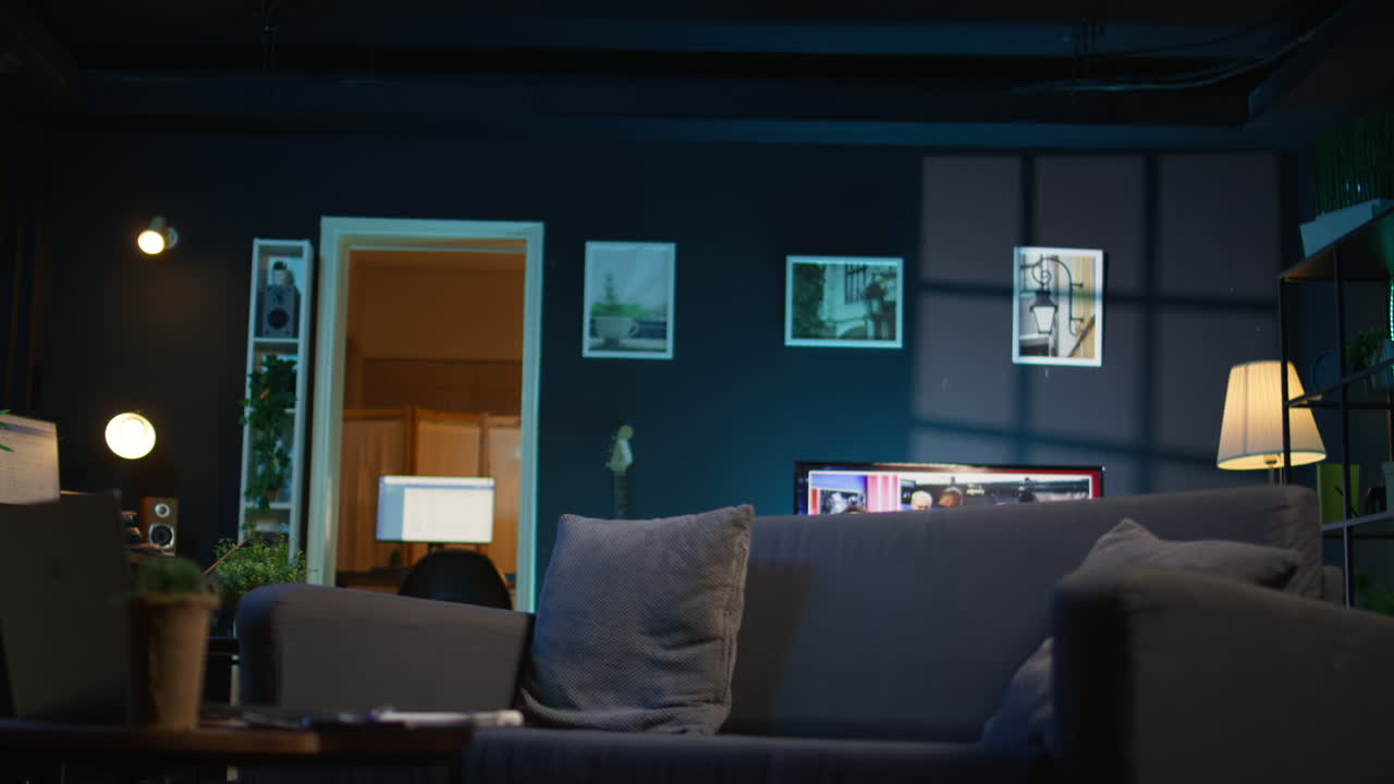 Cozy high end apartment illuminated with neon lights and a big tv, home theatre and setup for a young adult. Empty loft decorated and equipped with electronics, comfortable space.