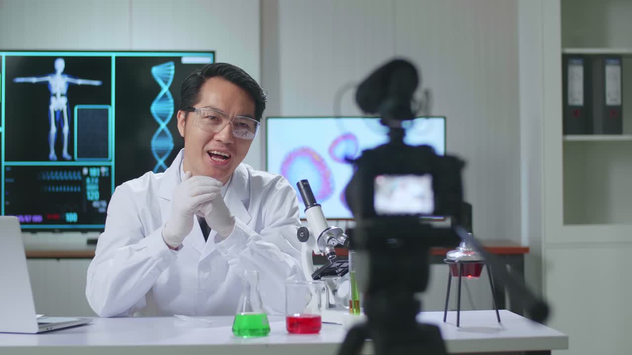 Asian Scientist In The Laboratory With A Microscope And Speaking To The Camera