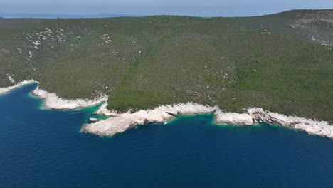 rocky white shoreline with turquoise water coves and dense green forested hills near dugi otok, croatia. panoramic drone aerial
