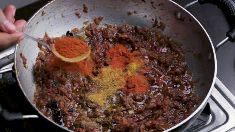 close up shot of an indian spicy masala paste mixing in hot oil for food preparation.