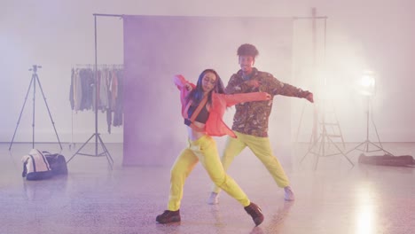 portrait of happy diverse male and female dancers dancing in dance studio, slow motion