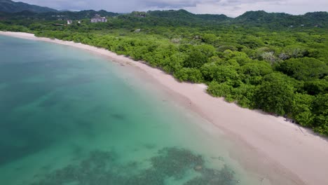 A-low-flying-4K-drone-shot-of-Playa-Conchal,-or-“Shell-Beach”,-and-Puerto-Viejo,-next-to-the-Mirador-Conchal-Peninsula,-along-the-north-western-coast-of-Costa-Rica