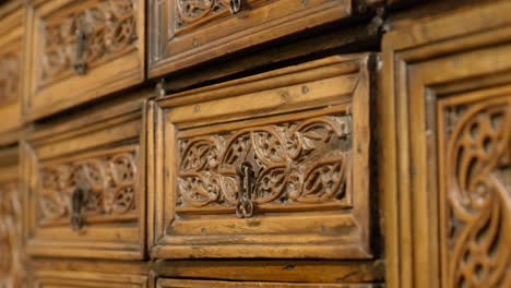 tracking shot of carved drawer detail, antique wooden furniture in slow motion