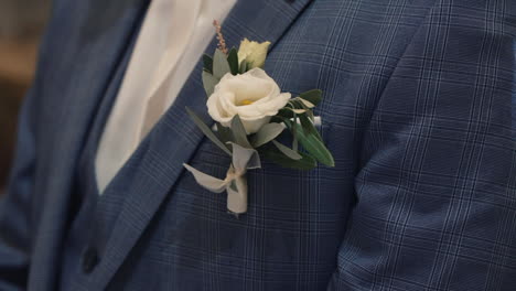 groom's boutonniere on blue checkered suit