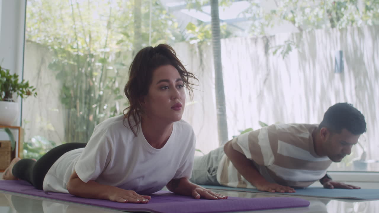 Couple of Young Man and Woman Lying on Floor in Sphinx Pose
