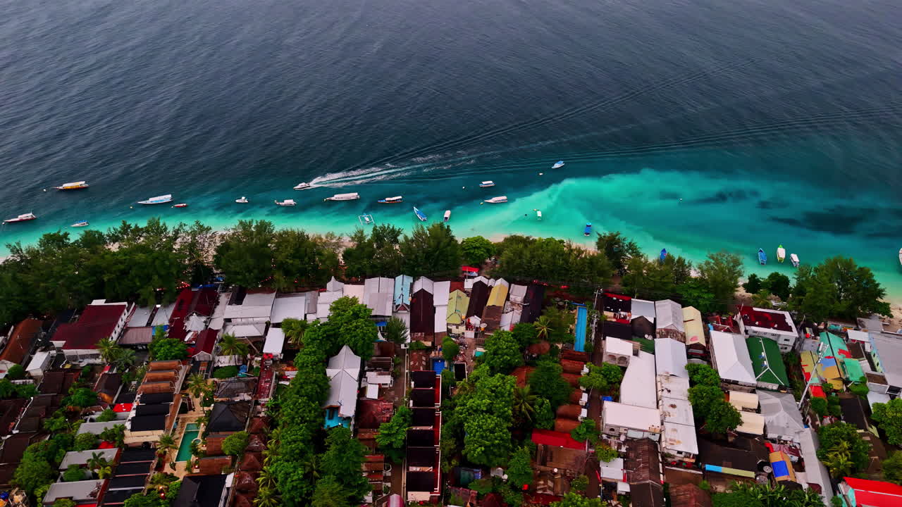 Tropical beach, boats, and rooftops in gili trawangan, indonesia, aerial view