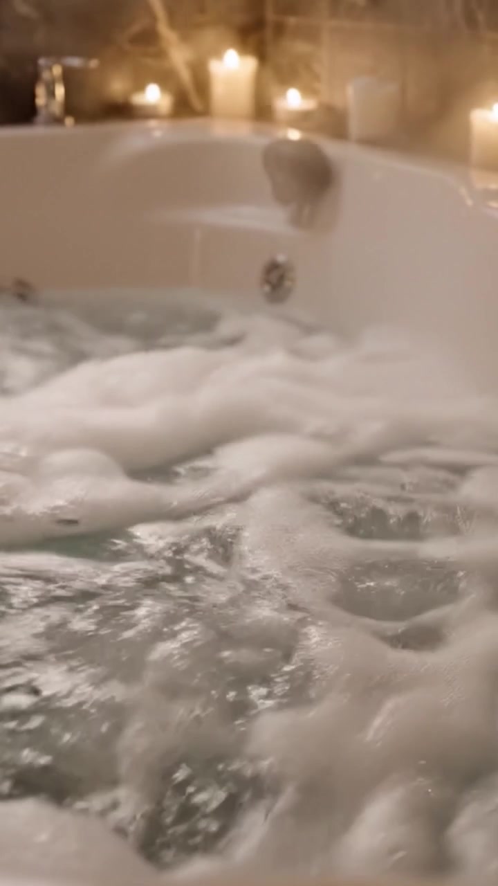 Relaxing Spa Bath: A Tranquil Moment of Serenity in a Bubble-filled Whirlpool with Candles for Ultimate Calmness and Rejuvenation