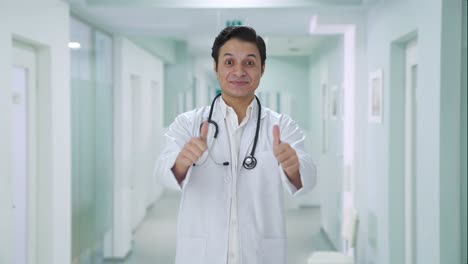 médico indio feliz mostrando los pulgares hacia arriba