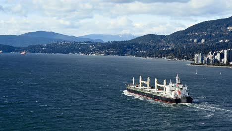 the importance of shipping: a container ship departs the terminal at vancouver harbour