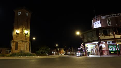 vehicles pass by a historic building at night