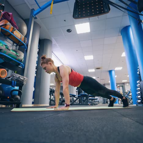 young girl in sportswear training in the gym. active woman doing workout on a mat in the modern fitness centre. healthy lifestyle.