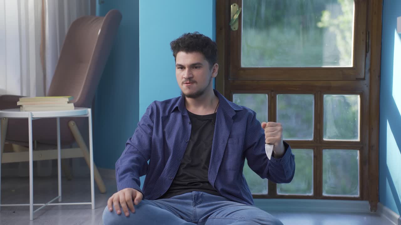 공격적이고 정신나간 남자가 칼로 놀고 있어요.