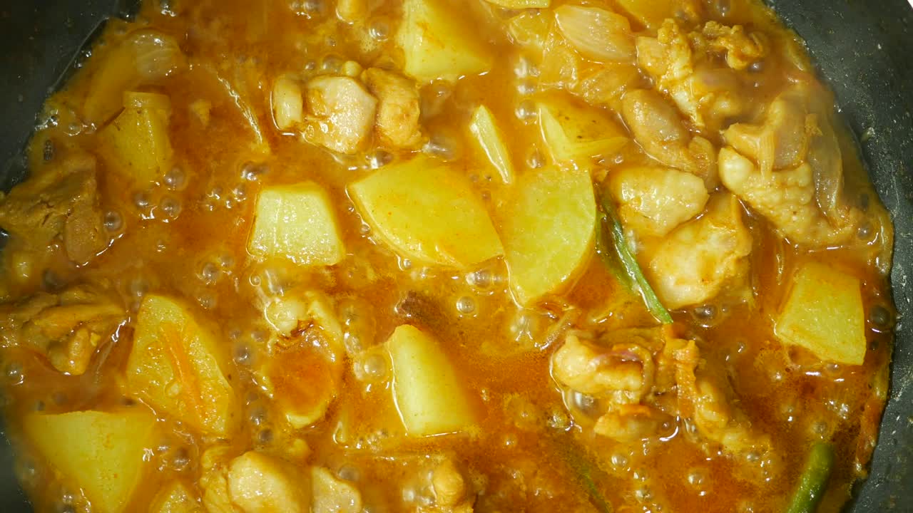 cocinando pollo con curry en una sartén ,
