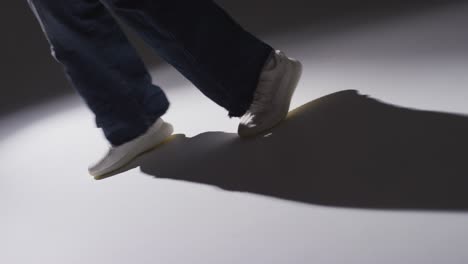 회색 배경 2에 비해 낮은 키 조명과 함께 춤추는 여성의 발을 보여주는 클로즈업 스튜디오  ⁇