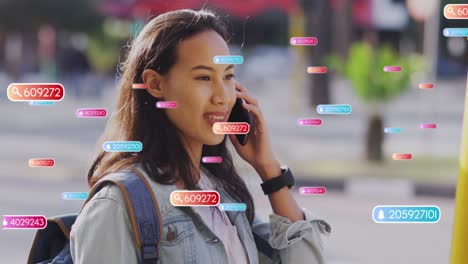 animación de iconos de las redes sociales contra una mujer asiática feliz hablando con un teléfono inteligente en la calle