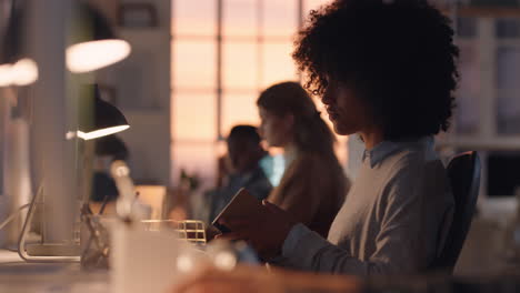 young african american business woman with afro working late using computer typing emails enjoying online network support in office at sunset