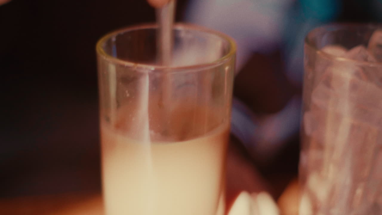 agitando un líquido blanco en un vaso