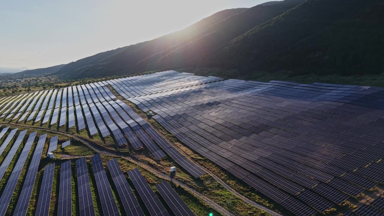 Solcellepaneler på en mark under solnedgang i et landområde