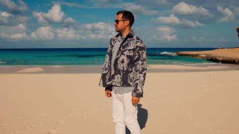 tourist standing alone on white sand beach, cleopatra beach lagoon in marsa matrouh, egypt