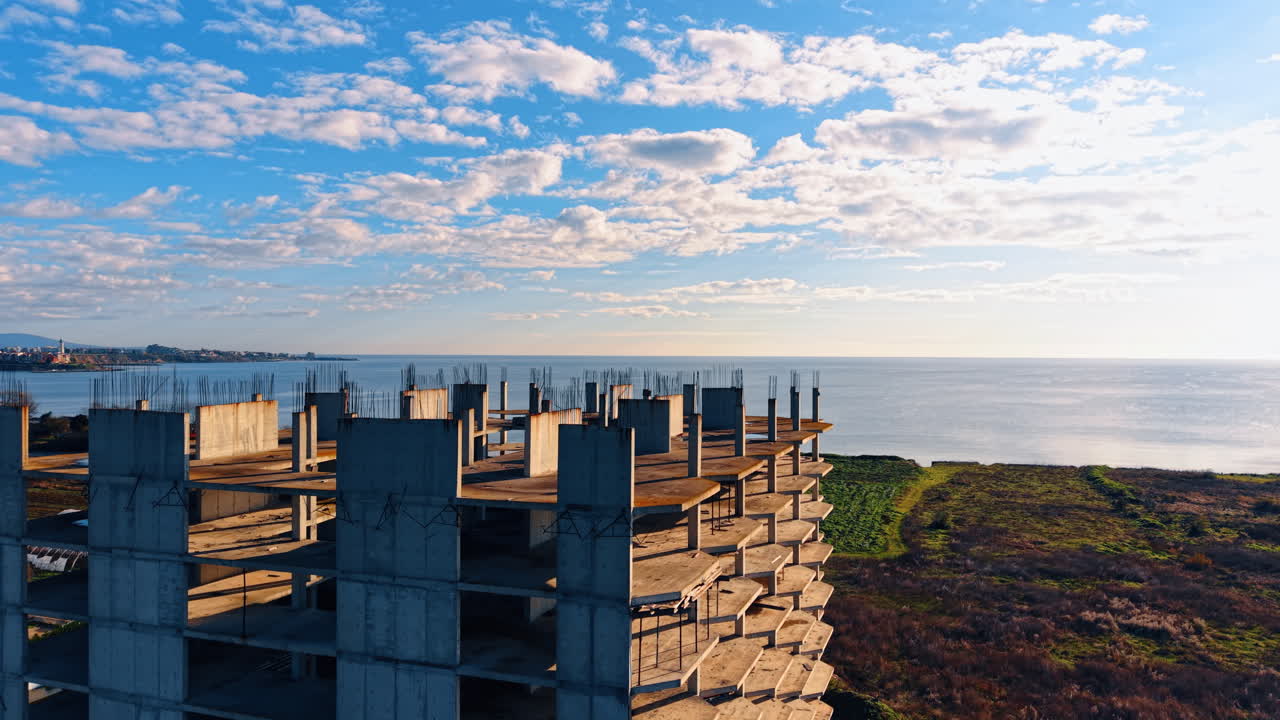 Scheletro di cemento per il futuro edificio a più piani. Scenario spettacolare del paesaggio marino e splendido cielo azzurro con nuvole soffici sullo sfondo