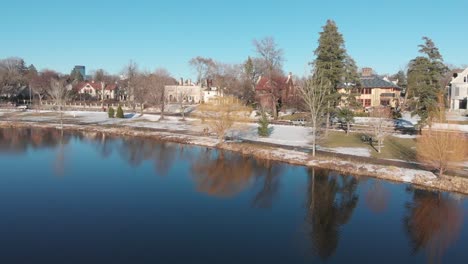 Following-a-car-on-a-nice-neighborhood,-road-by-the-lake-shores-during-a-sunny-afternoon