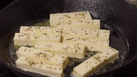 la mantequilla chisporrotea en la sartén de hierro fundido caliente como fritas de queso de hierba, de cerca