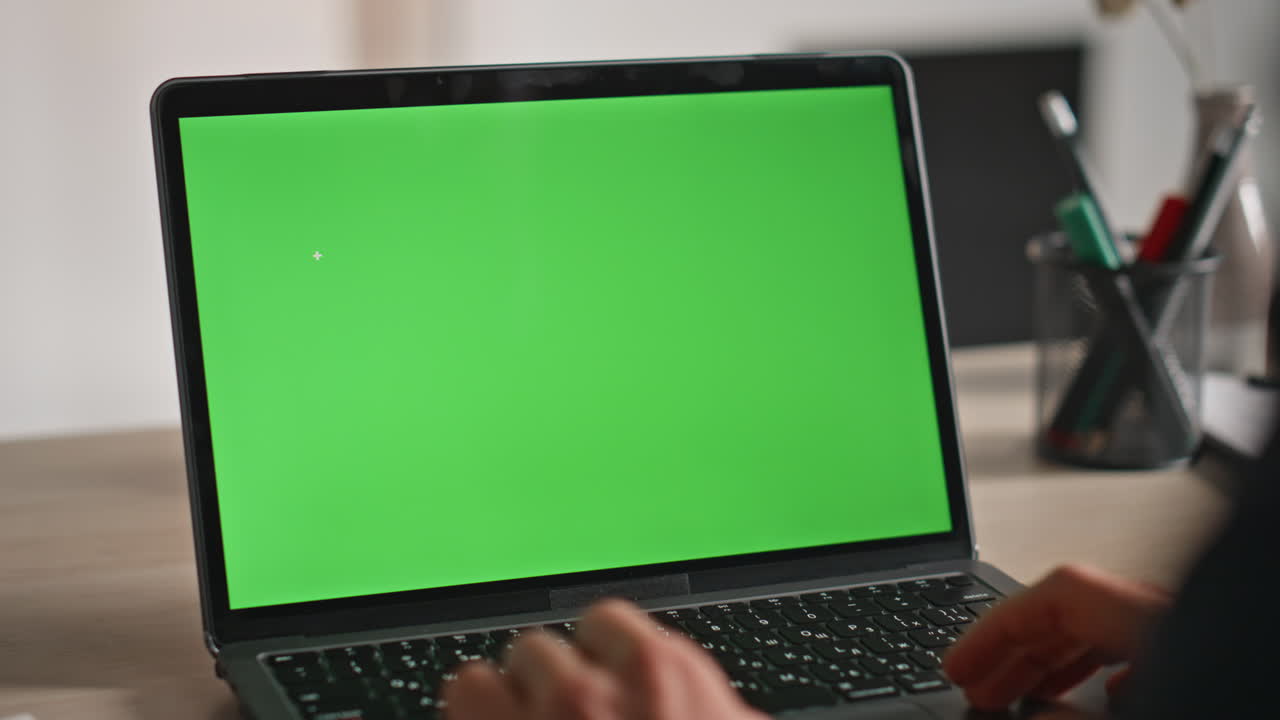 Unknown freelancer working green screen laptop in modern workplace closeup