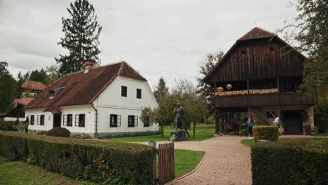 historic croatian village scene with a statue and traditional houses in kumrovec, croatia