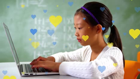 múltiples iconos de corazón azul y rojo flotando sobre una chica asiática usando una computadora portátil en la clase en la escuela