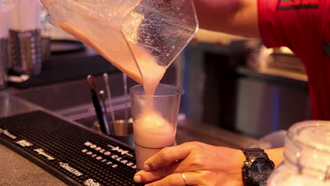 bartender pours slurpee into a glass