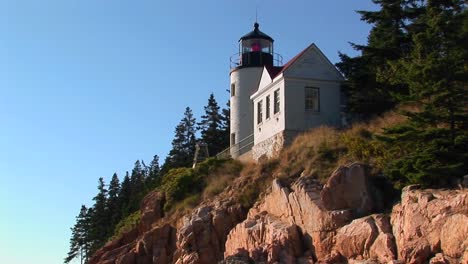 a lighthouse on the edge of a cliff overlooking the ocean in bass harbor lighthouse maine 3