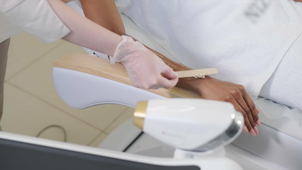 미용실에서 레이저 제거 및 화장품. 화장품, 스파 및 탈모 개념. 여성 손의 레이저 탈모 절차. 장갑을 입은 의사.