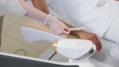 laser epilation and cosmetology in beauty salon. cosmetology, spa and hair removal concept. laser hair removal procedure of female hands. doctor in gloves.